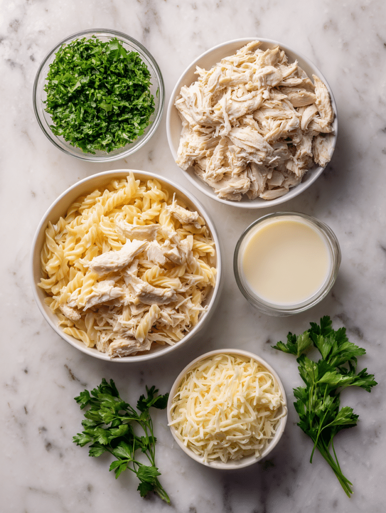 Chicken Alfredo casserole ingredients on a marble counter